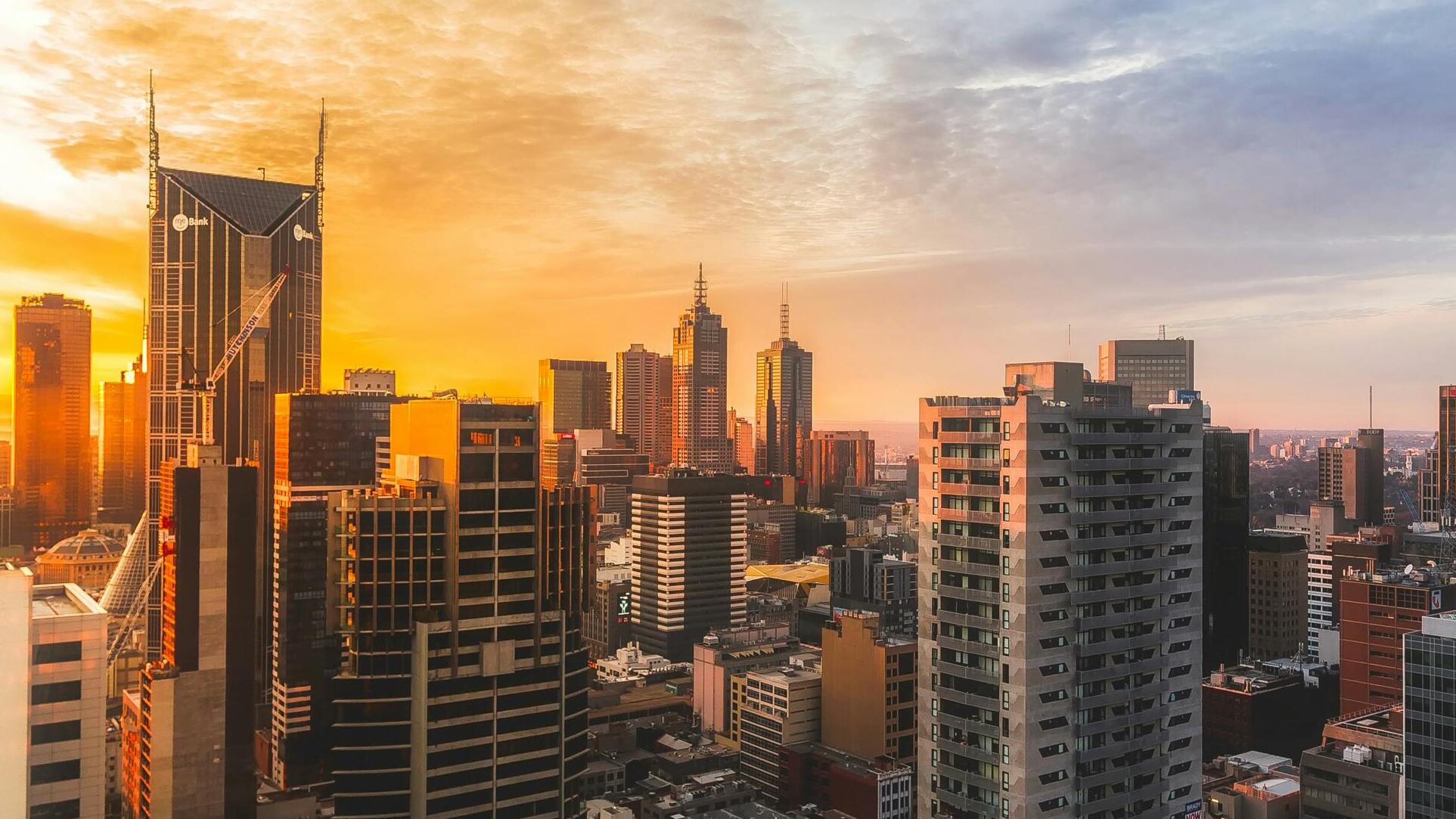 Sun setting and reflecting off buildings in city block 